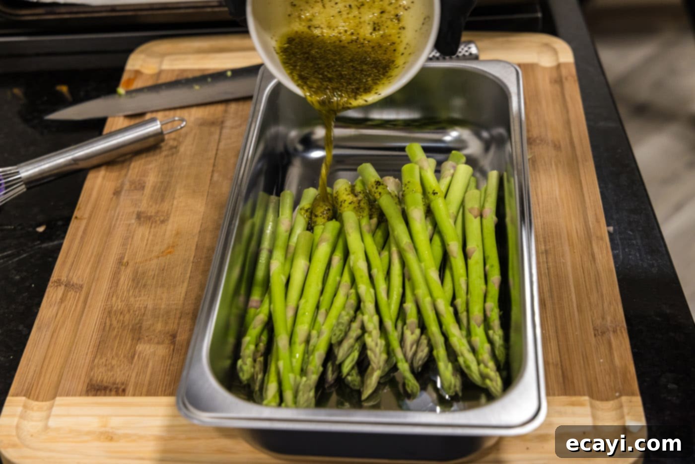 Crispy Prosciutto-Wrapped Asparagus 6 pouring olive oil seasoning mixture over asparagus spears