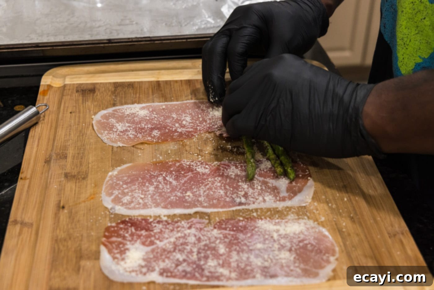 Crispy Prosciutto-Wrapped Asparagus 9 hands rolling asparagus spears in prosciutto