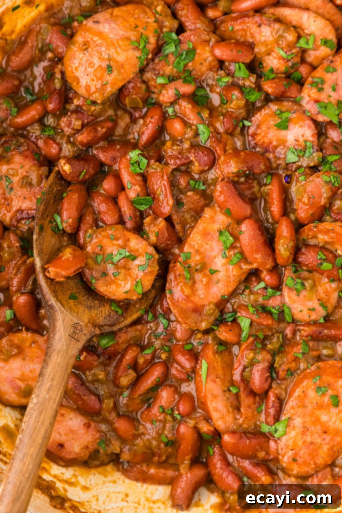 Hearty Louisiana Red Beans and Rice 3 Close up photo of Cajun Red Beans in a skillet with a spoon, highlighting the rich texture