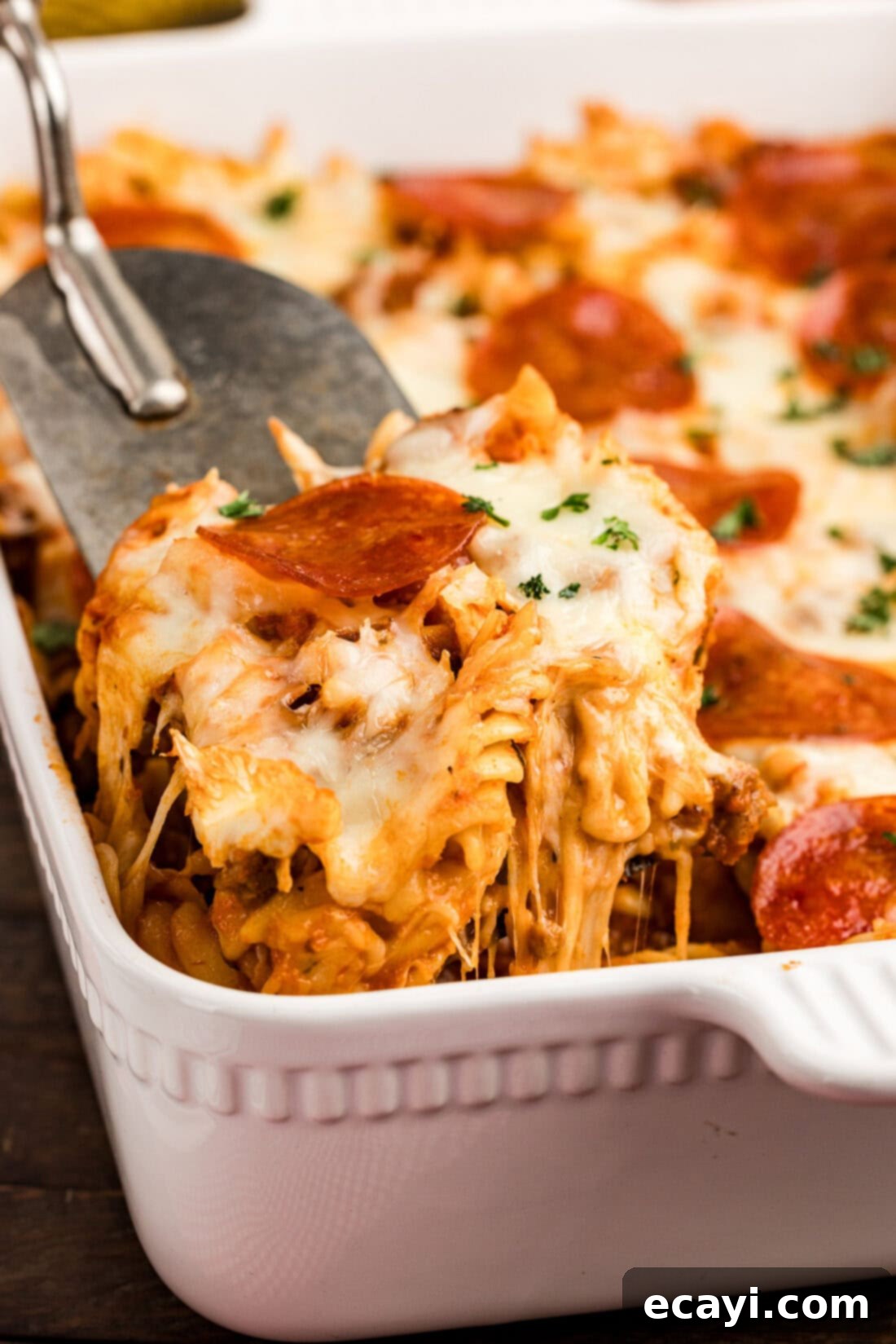 Ultimate Sausage and Pepperoni Pizza Bake 3 Scoop of Sausage & Pepperoni Pizza Casserole being lifted out of the casserole dish