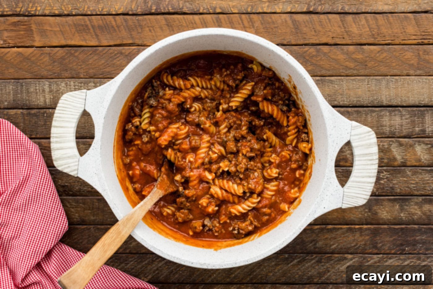 Ultimate Sausage and Pepperoni Pizza Bake 6 rotini pasta with marinara and sausage in a mixing bowl