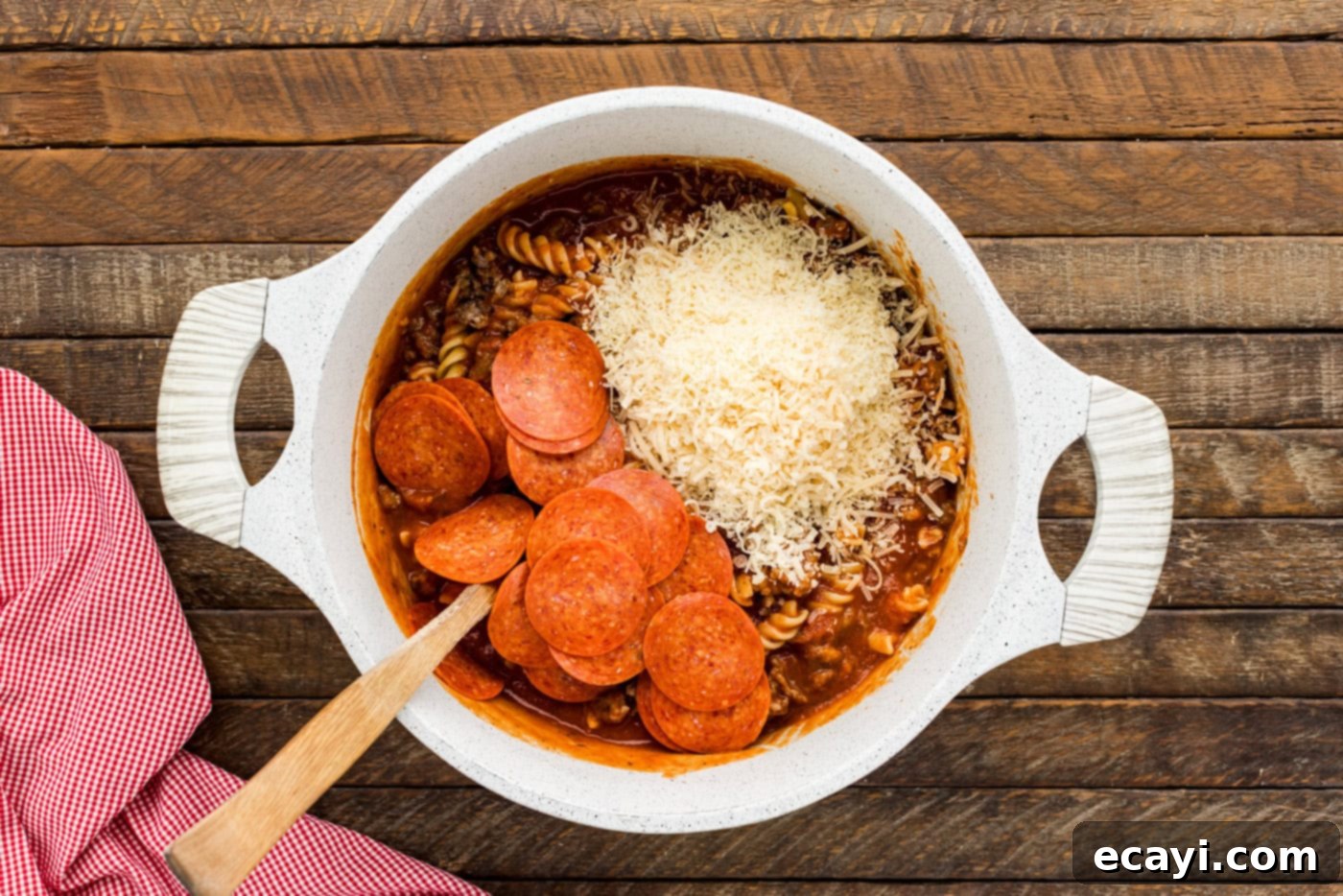 Ultimate Sausage and Pepperoni Pizza Bake 7 pepperoni and cheese added to pasta in a bowl
