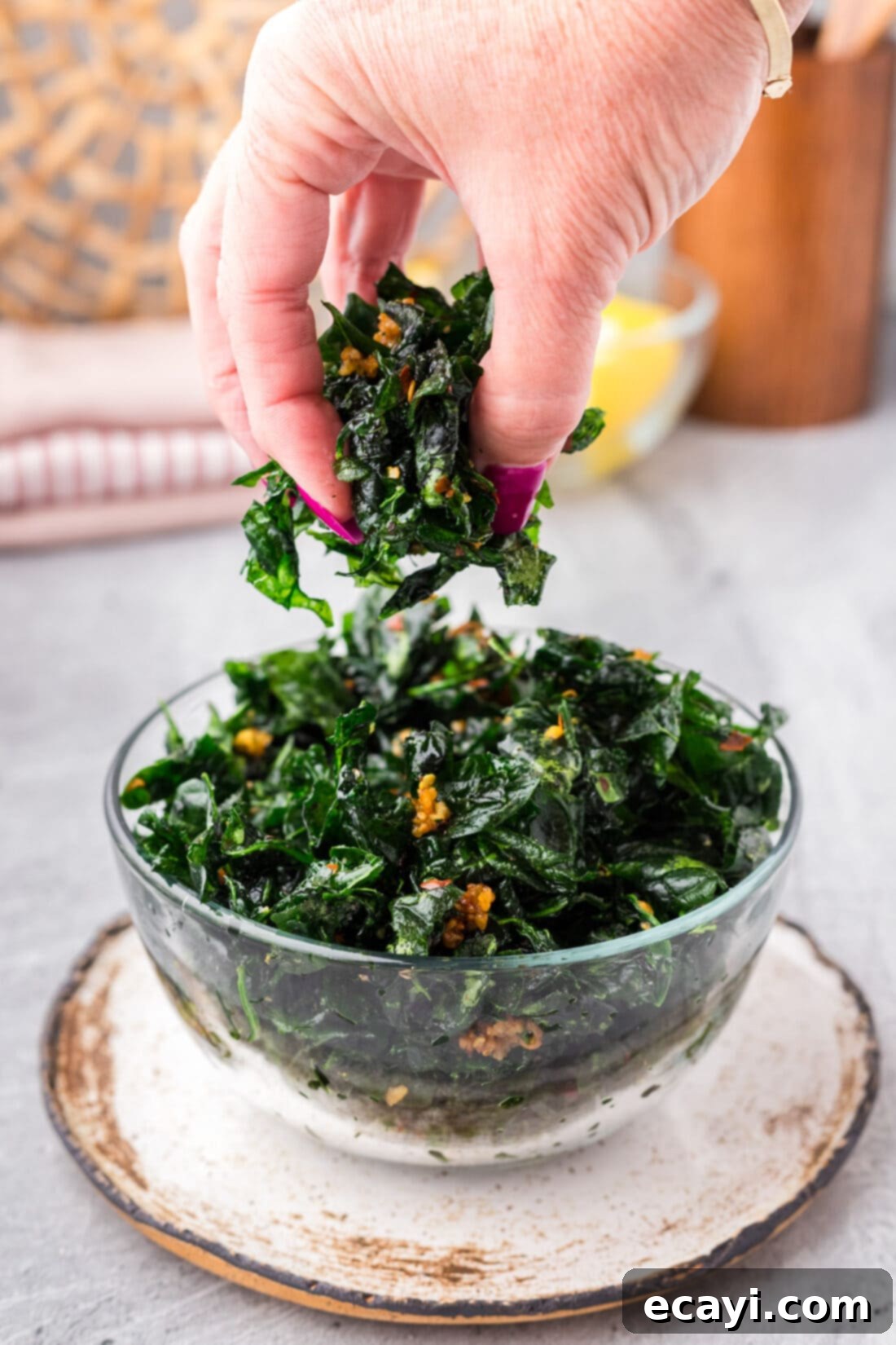 Crispy Spinach Sauté 3 A hand reaching into a bowl of perfectly golden and crispy Fried Spinach.