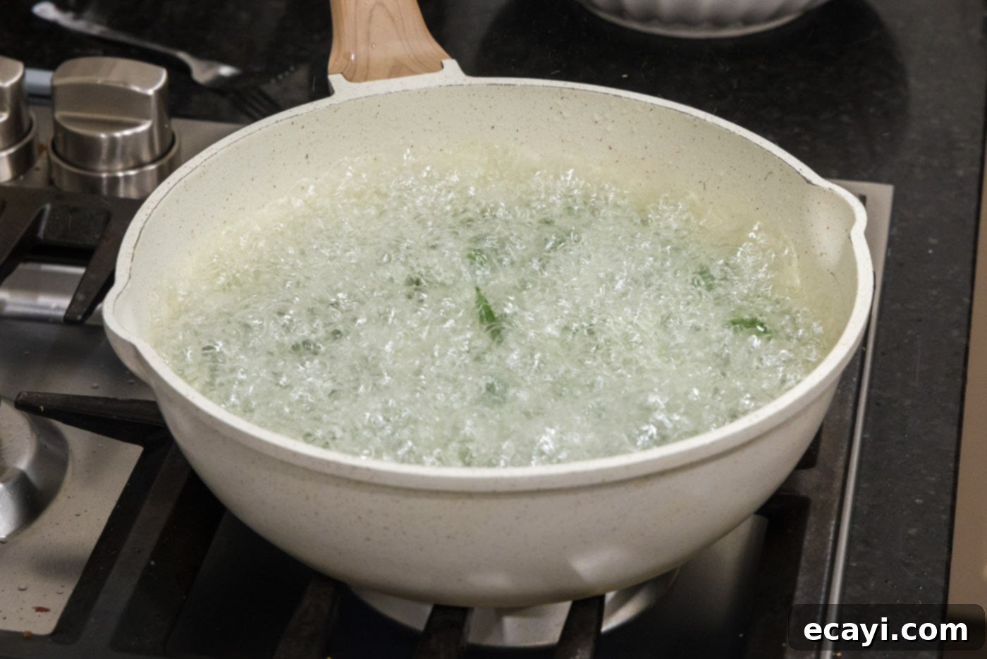 Crispy Spinach Sauté 6 Mid-shot of spinach leaves actively frying and bubbling in hot oil in a skillet.