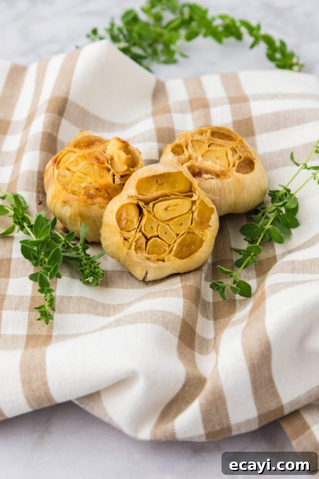 Roasting Garlic Made Easy 3 Three bulbs of roasted garlic on a towel