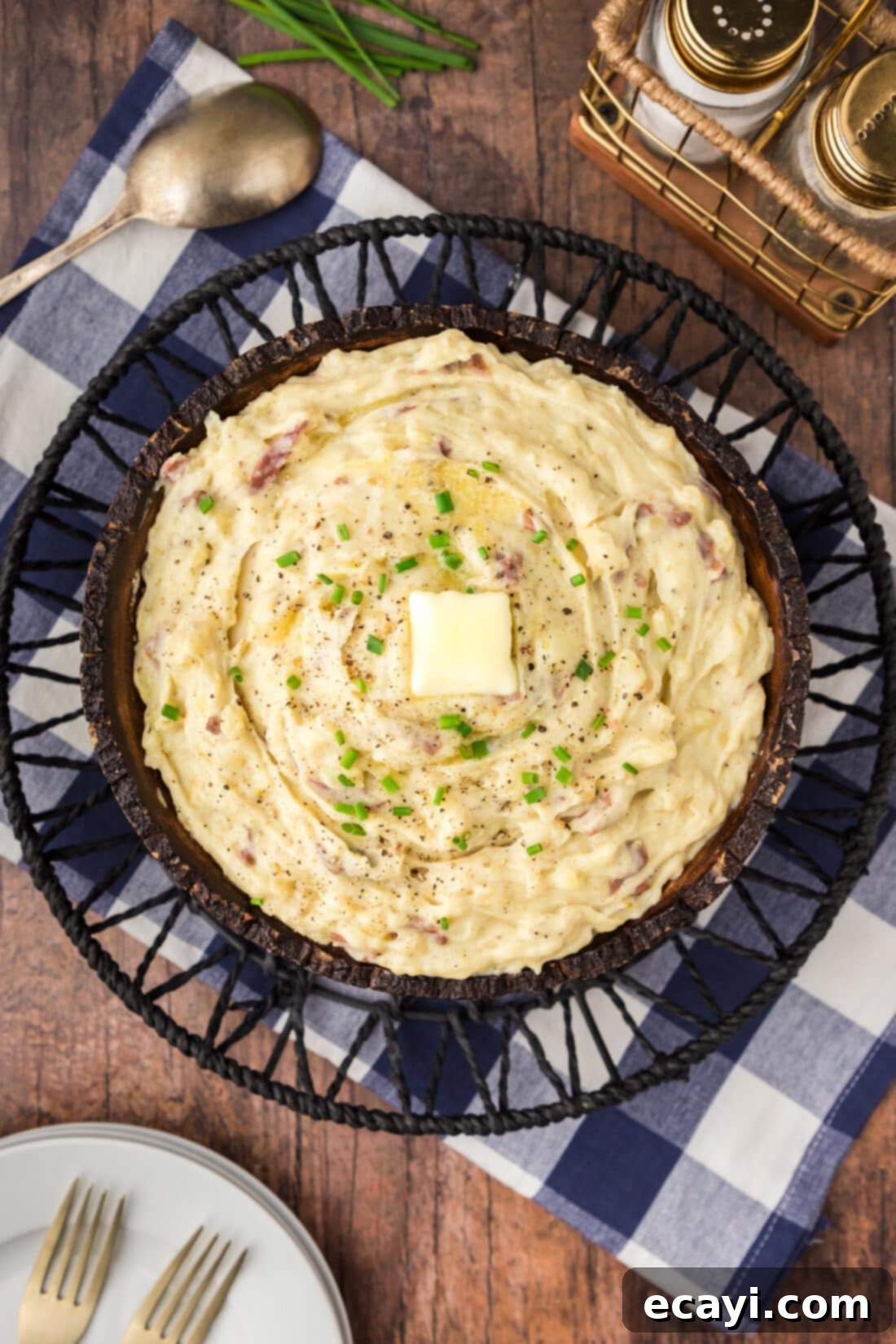 Creamy Garlic Mash 2 Overhead shot of a large bowl of luscious, golden-white garlic mashed potatoes, garnished with fresh herbs and a melted pat of butter, ready to be served.