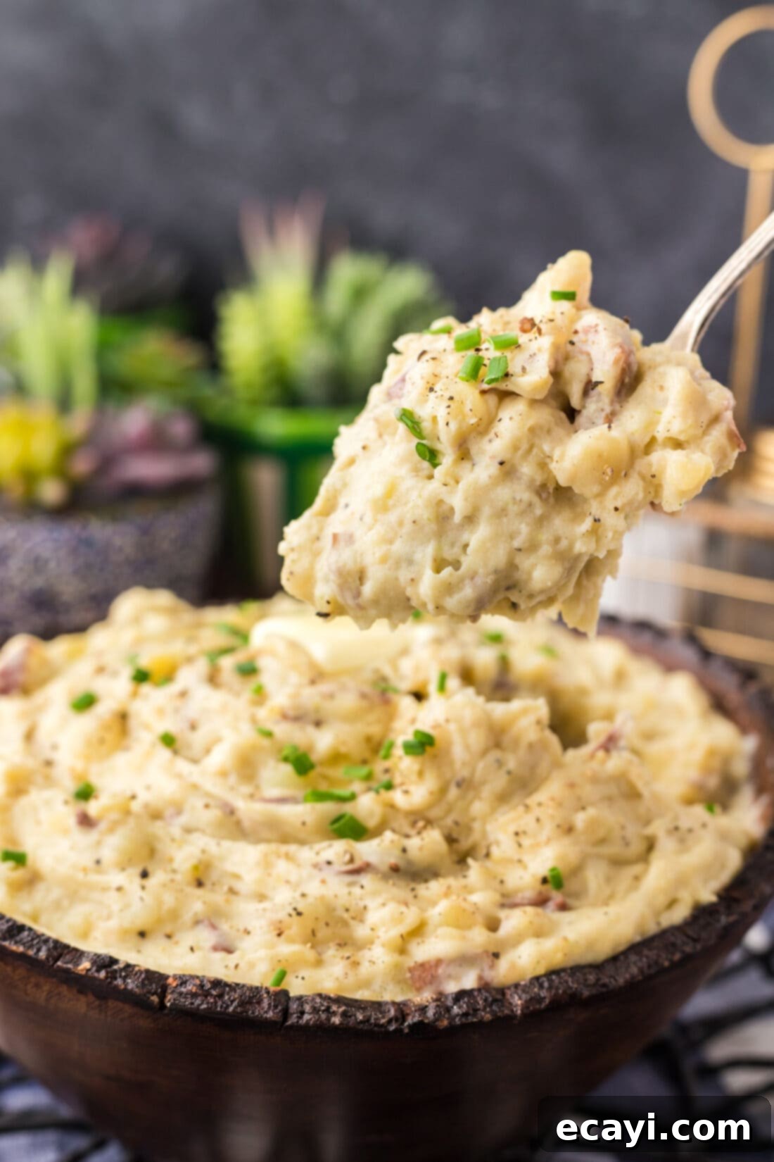 Creamy Garlic Mash 13 A spoonful of fluffy, creamy garlic mashed potatoes being lifted gracefully above a full bowl, showcasing the rich texture and steam.