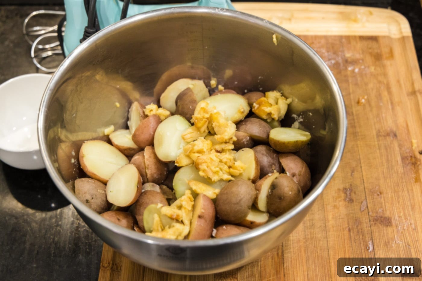 Creamy Garlic Mash 9 Roasted garlic cloves and tender baby red potatoes nestled together in a large mixing bowl, awaiting the creamy additions.