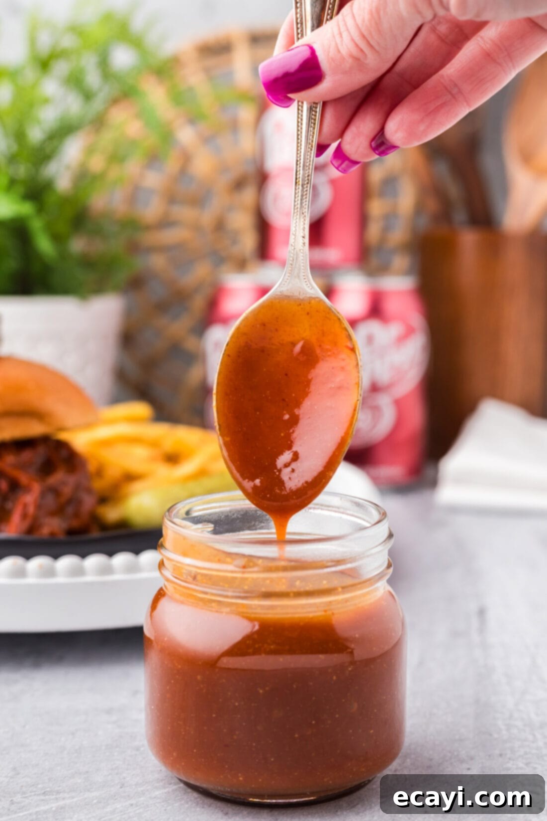 Dr Pepper Infused BBQ Sauce 2 Dr Pepper Barbecue Sauce dripping off a spoon into a jar