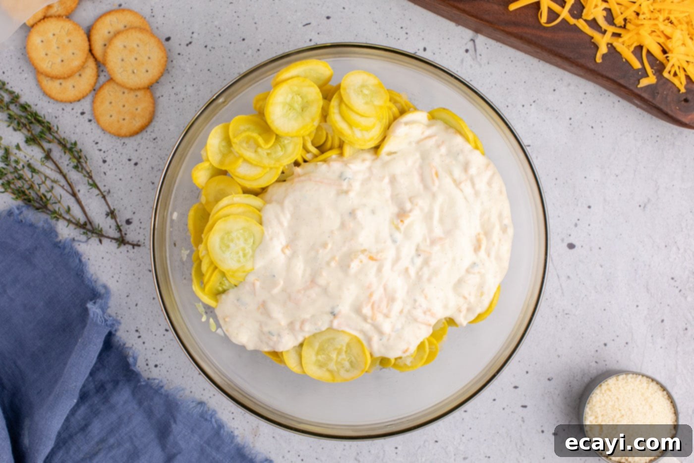 Golden Squash Bake 9 adding sour cream filling to sliced yellow squash in a mixing bowl
