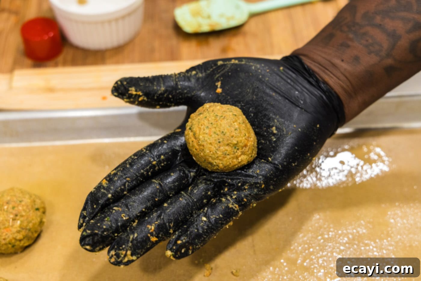 Hearty Lentil Meatballs 11 hand holding rolled lentil meatball