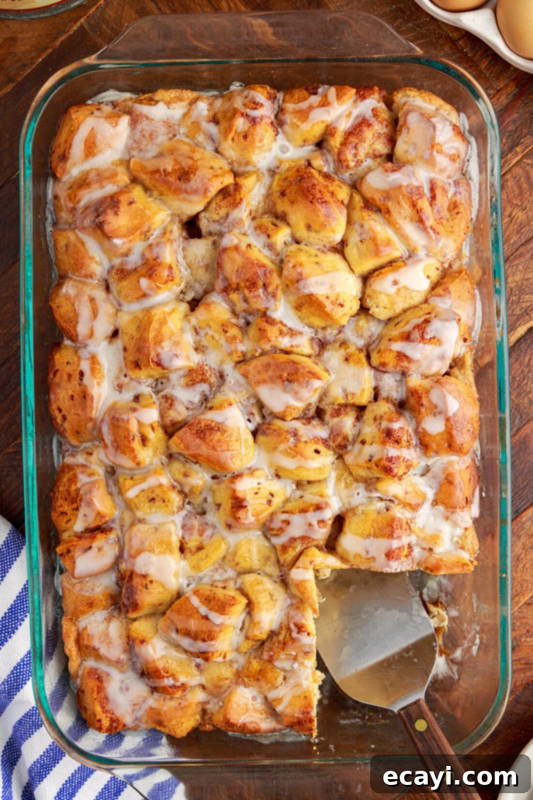 Gooey Cinnamon Brunch Bake 2 Cinnamon Roll Casserole with a serving removed, showcasing its gooey center and golden-brown top