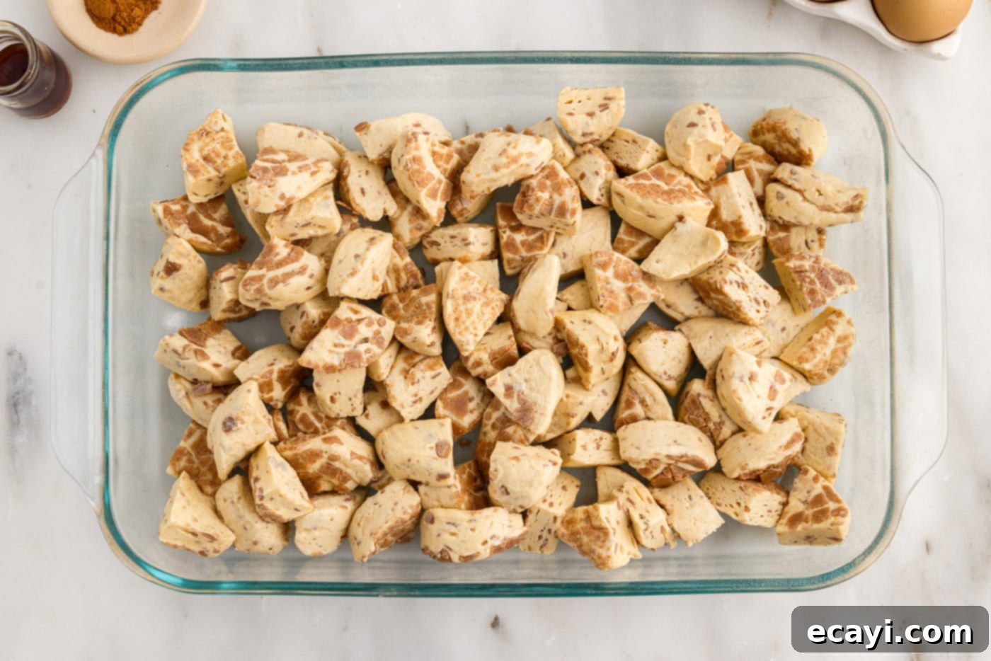 Gooey Cinnamon Brunch Bake 6 quartered cinnamon rolls spread out in a baking dish