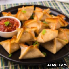 Golden Crab Cream Crisps 13 Close up photo of Crab Rangoons on a plate with dipping sauce