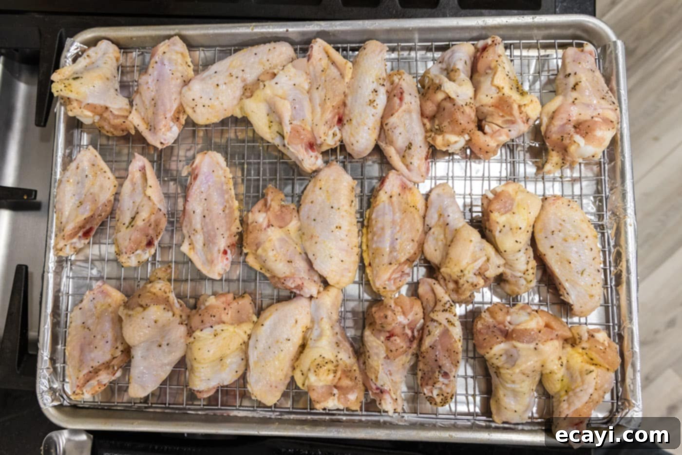 Sticky Honey Garlic Wings 6 raw chicken wings on a baking sheet