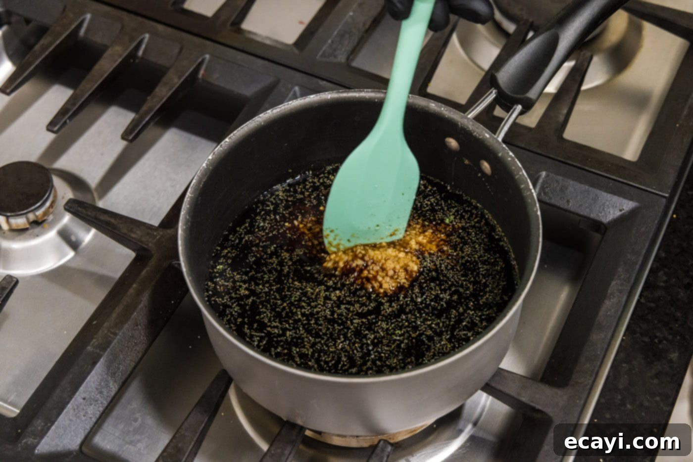 Sticky Honey Garlic Wings 7 stirring honey garlic sauce in a saucepan