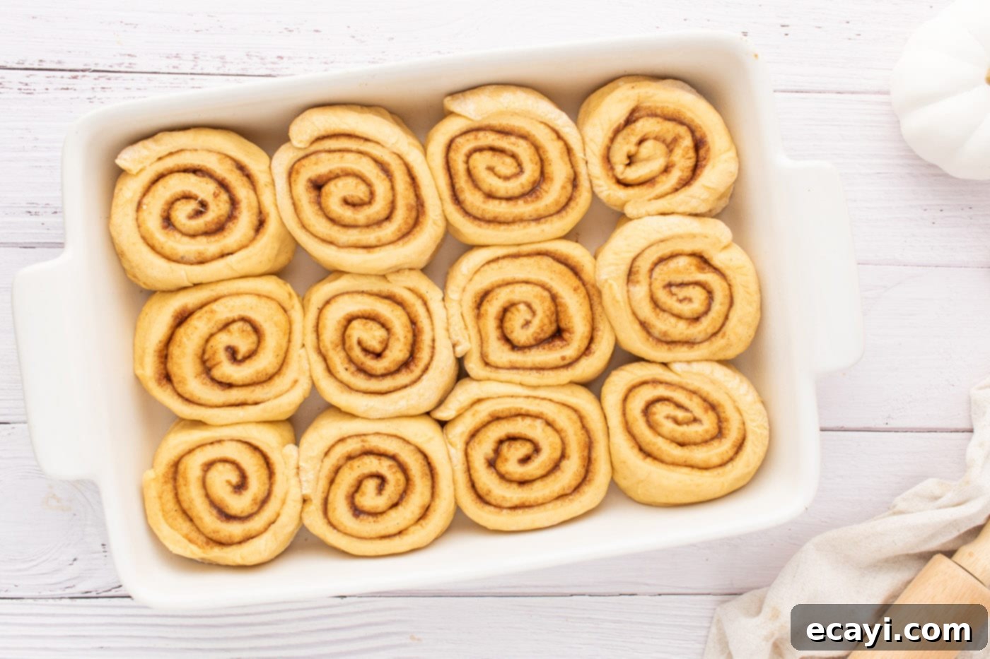 Golden Pumpkin Spiced Swirls 14 sliced cinnamon rolls arranged in a baking pan