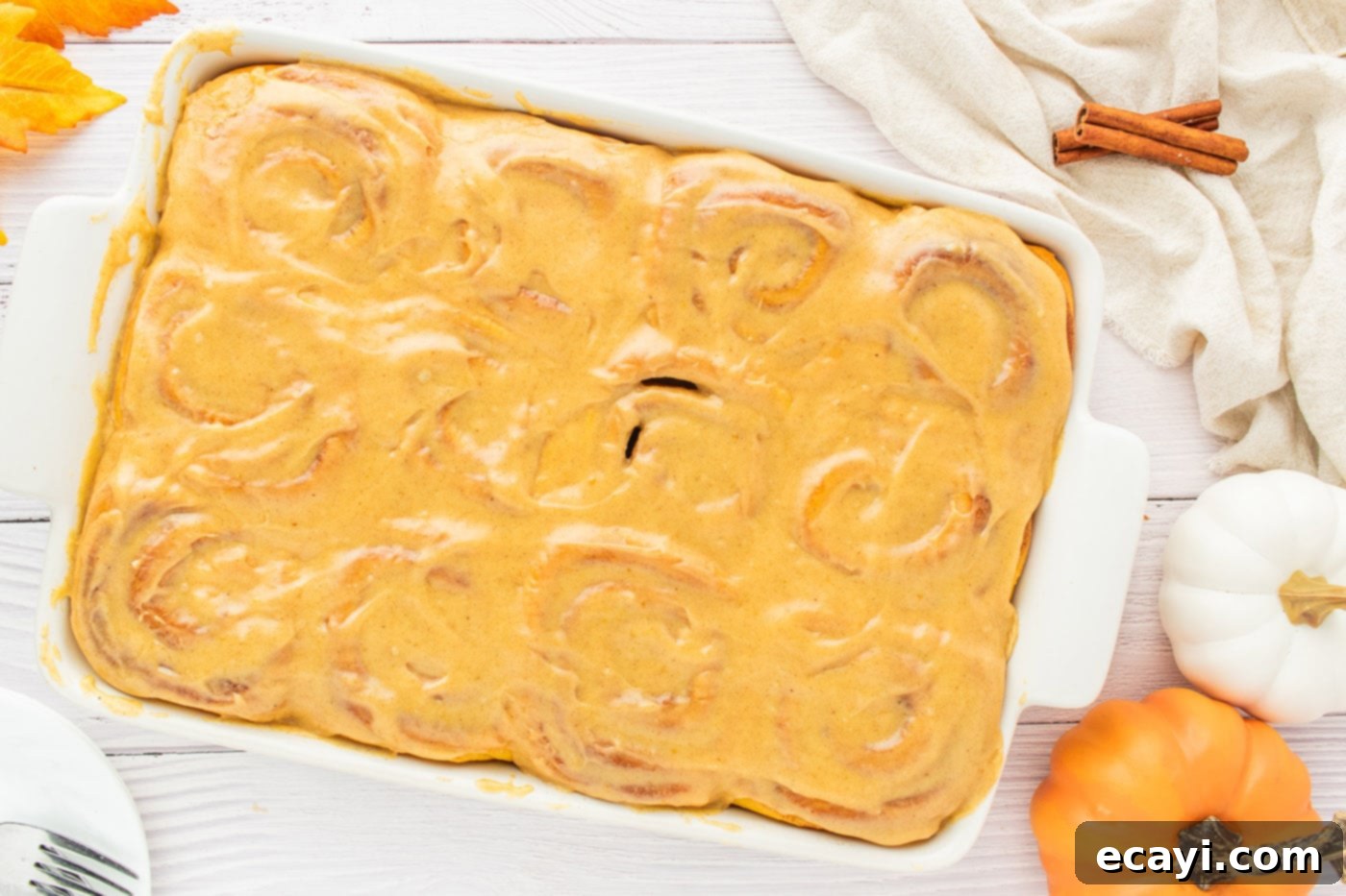 Golden Pumpkin Spiced Swirls 18 pumpkin cinnamon rolls topped with pumpkin cream cheese frosting, ready to be served
