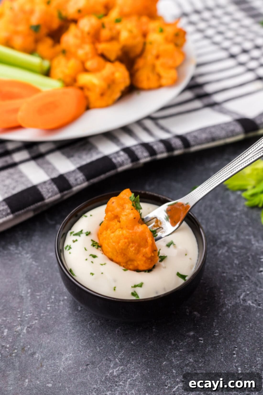 Buffalo Cauliflower Bites 14 Buffalo Cauliflower being dipped into ranch dressing with celery and carrots