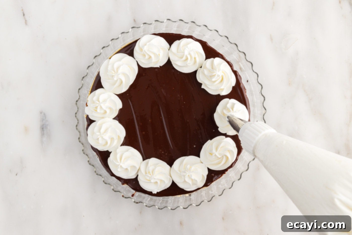 Irresistible Baileys Cheesecake 16 piping whipped cream onto cheesecake