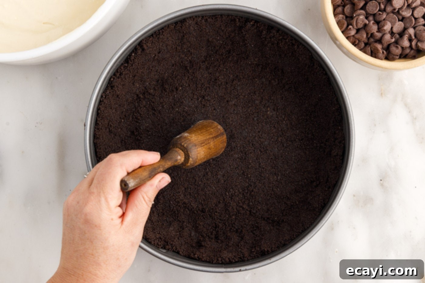 Irresistible Baileys Cheesecake 7 flattening oreo crumbs into a springform pan