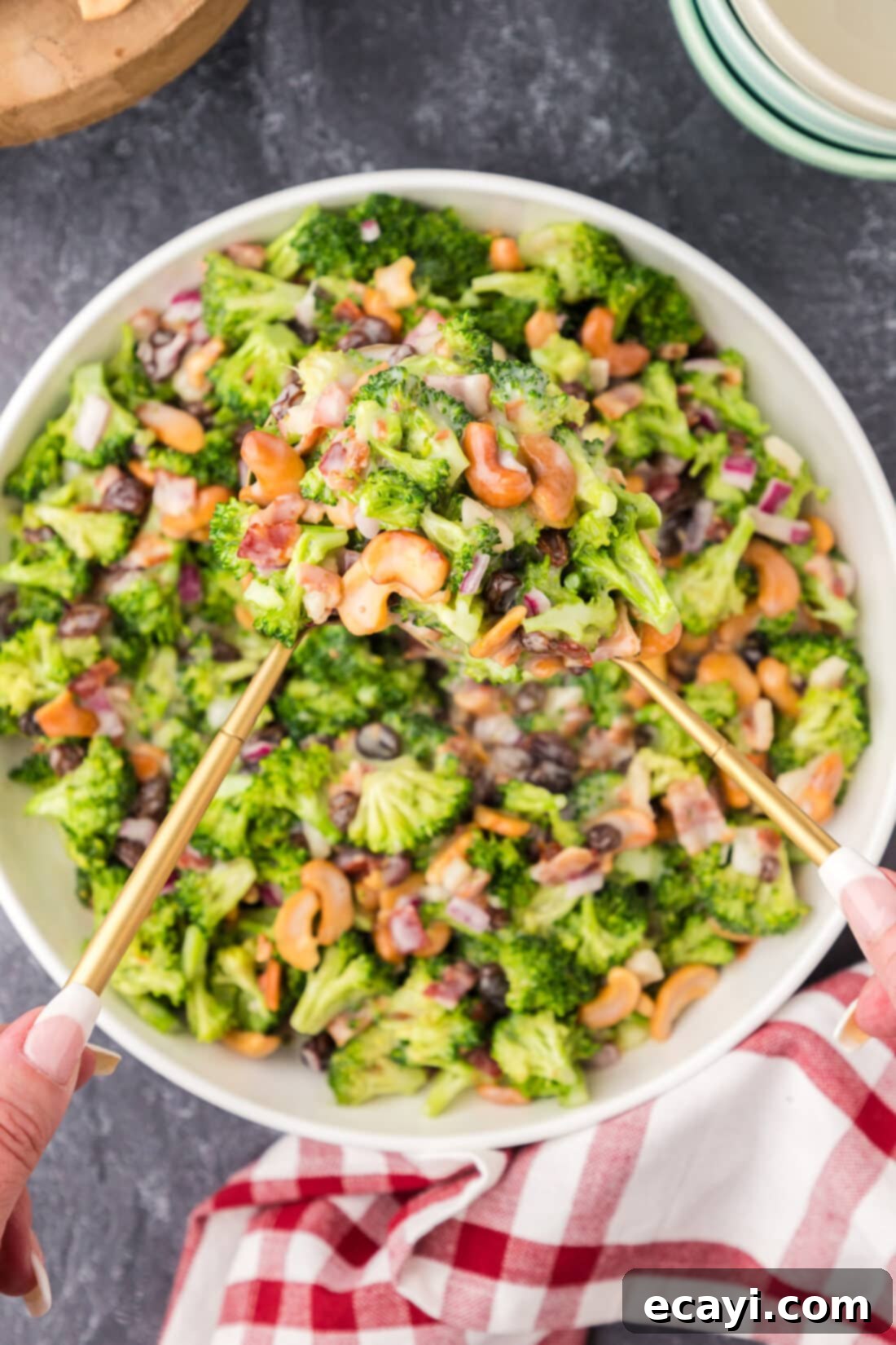 Garden Cashew Crunch 10 Two spoons holding up Broccoli Cashew Salad from a bowl