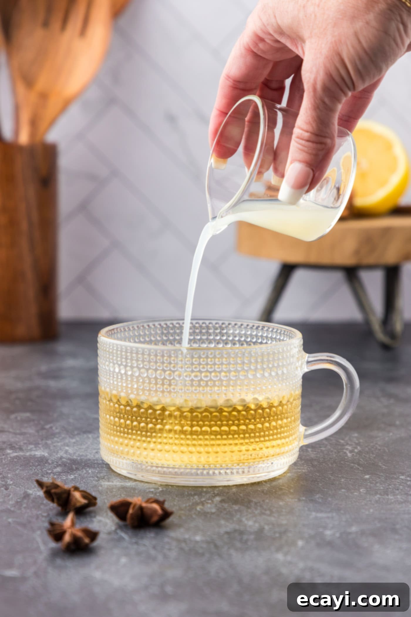 Cozy Comfort Brew 6 pouring lemon juice into glass with whiskey and water
