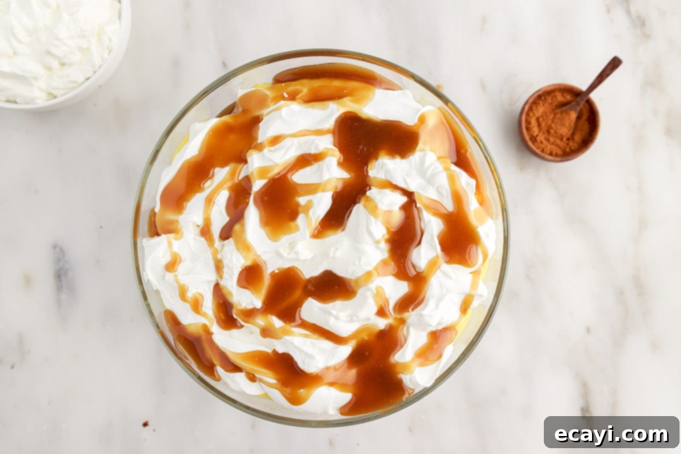 Gingerbread Layered Delight 12 The final layer of whipped cream and caramel sauce being added to the top of the gingerbread trifle