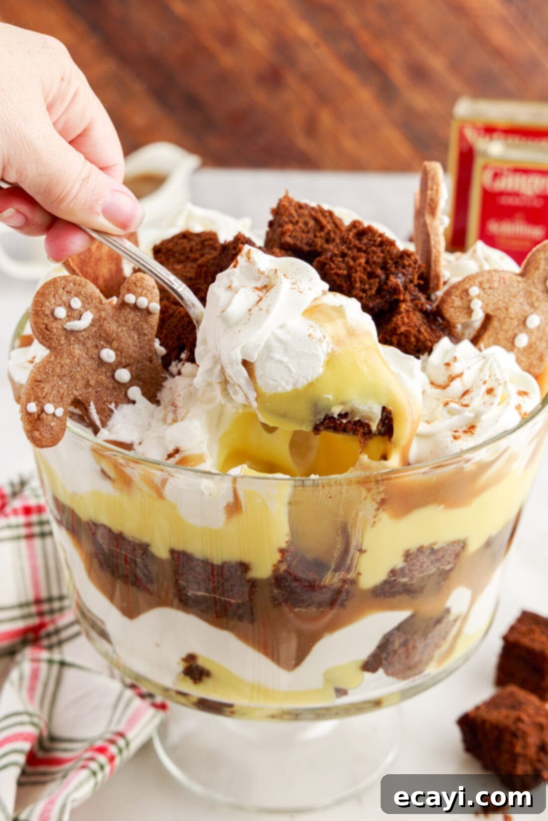 Gingerbread Layered Delight 3 A spoonful of Gingerbread Trifle being lifted from a clear trifle bowl, highlighting the layered dessert
