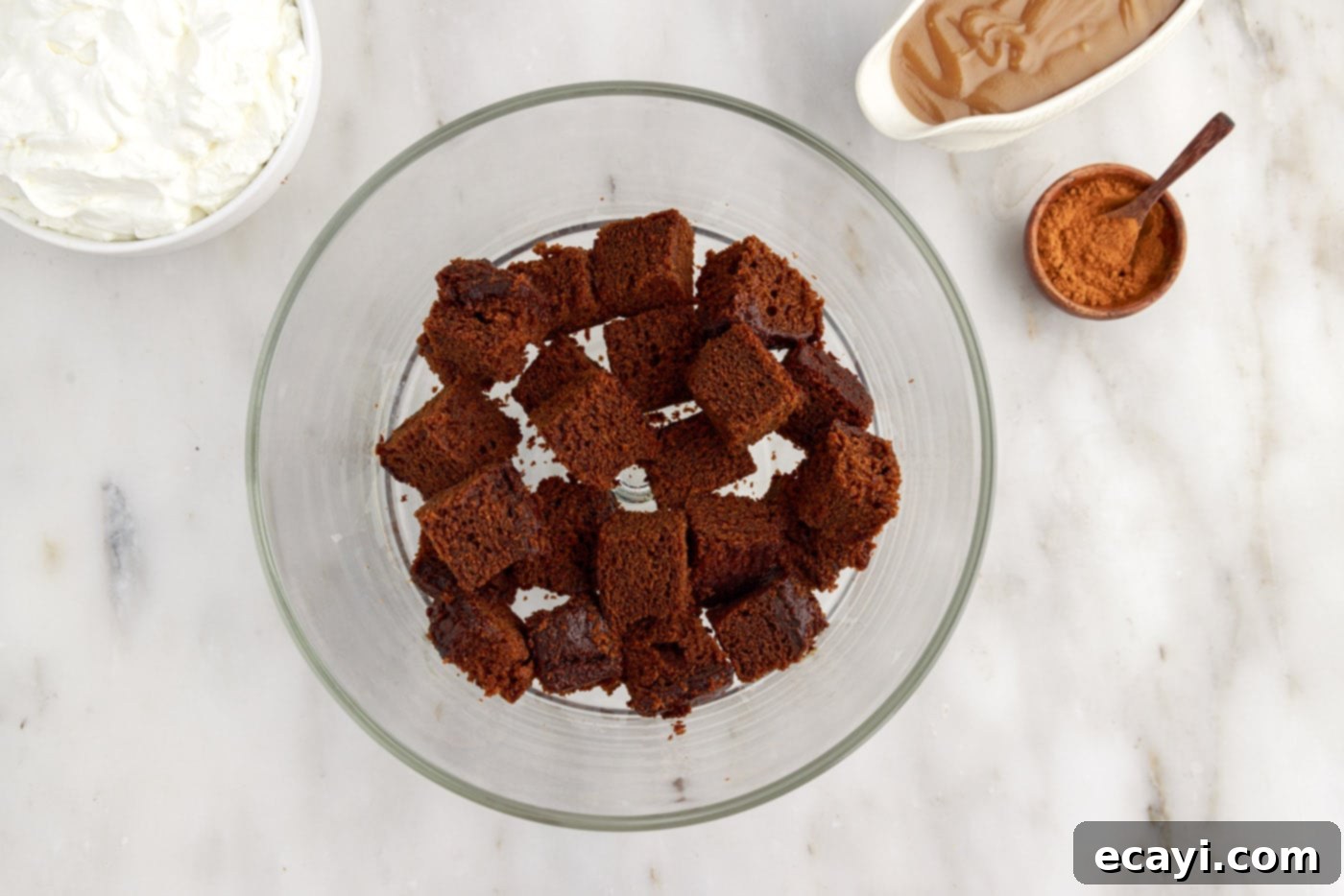 Gingerbread Layered Delight 7 Cubed gingerbread cake pieces forming the base layer in a clear trifle bowl