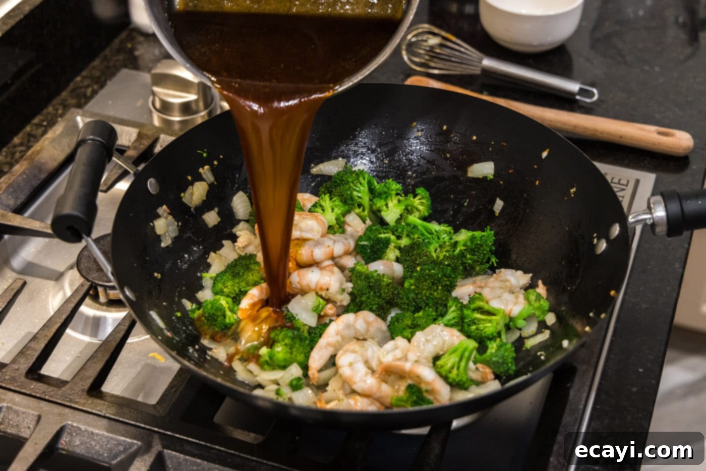 Garlic Shrimp & Broccoli Sauté 11 pouring thickened stir fry sauce over shrimp and broccoli in a wok
