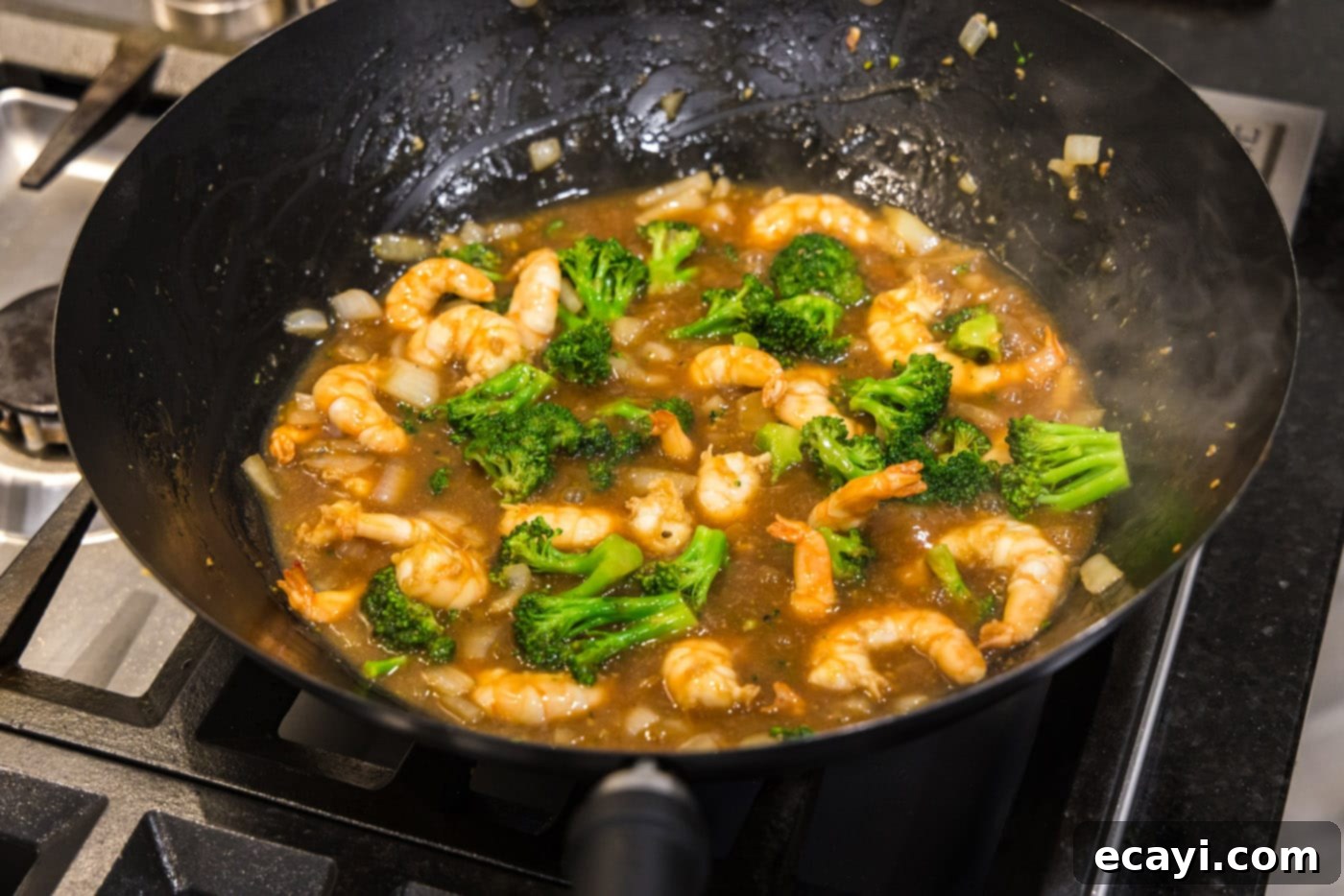 Garlic Shrimp & Broccoli Sauté 12 finished shrimp and broccoli stir fry in a wok, perfectly coated in sauce
