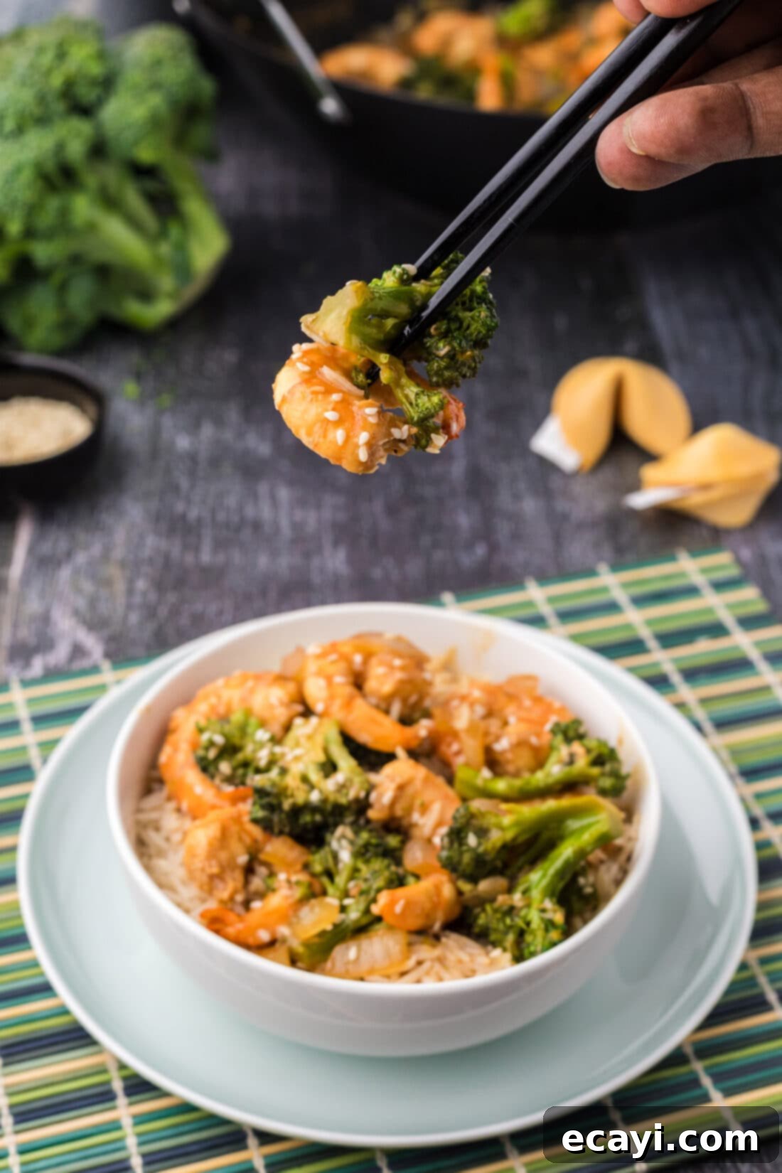 Garlic Shrimp & Broccoli Sauté 13 Close up of chopsticks holding up a piece of shrimp and broccoli from the stir fry