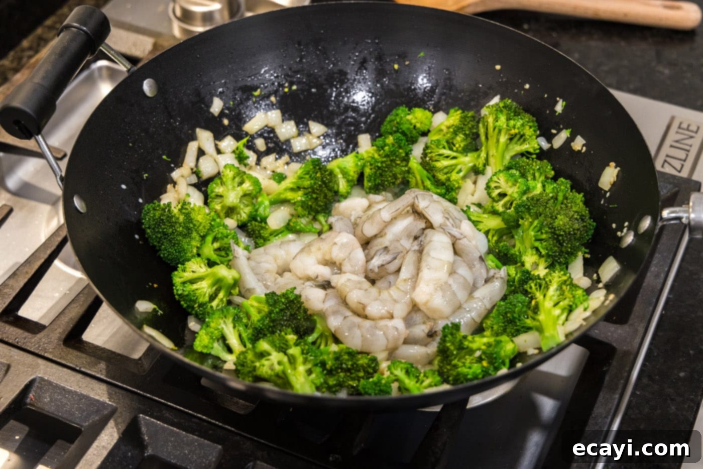 Garlic Shrimp & Broccoli Sauté 10 raw shrimp added to wok with broccoli and onion, ready for stir-frying