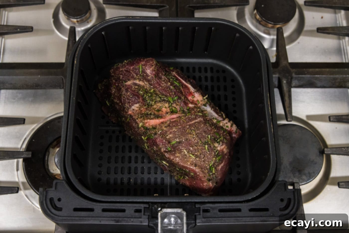 Perfect Air Fryer Roast Beef 7 A perfectly seasoned sirloin tip roast nestled comfortably in an air fryer basket, ready for cooking to create a tender and juicy meal.