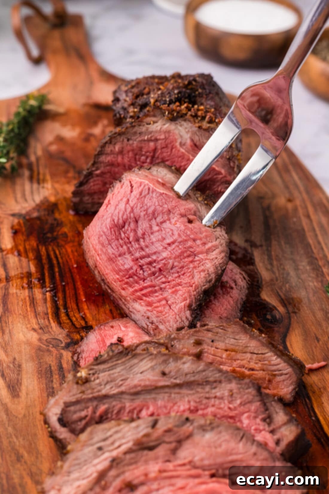 Perfect Air Fryer Roast Beef 8 A single, perfectly cooked slice of Air Fryer Roast Beef is held aloft on a carving fork, tempting with its tender appearance and savory juices.