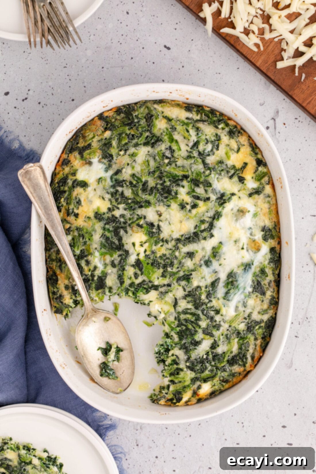 Savory Spinach Cloud 2 A golden-brown, fluffy spinach souffle baked to perfection, with a spoon resting invitingly in it, ready to be served as a delicious side or brunch dish.