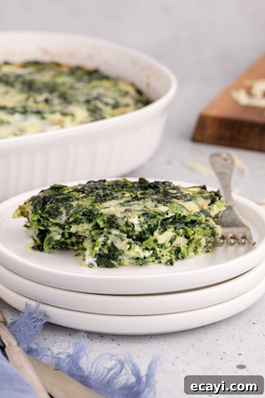 Savory Spinach Cloud 3 A generous serving of light and fluffy spinach souffle presented on a dinner plate, garnished slightly and ready for a meal.