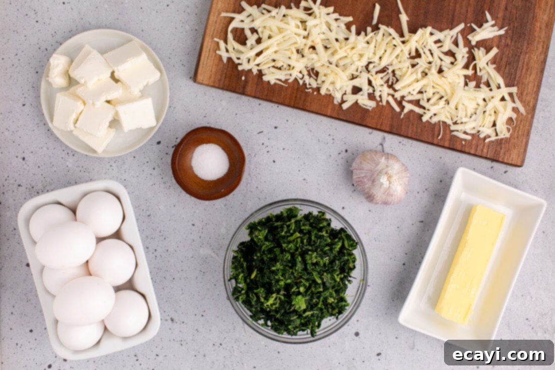 Savory Spinach Cloud 4 A flat lay photograph showcasing all the fresh ingredients needed for making spinach souffle, including eggs, blocks of cheese, garlic cloves, and a bag of spinach.