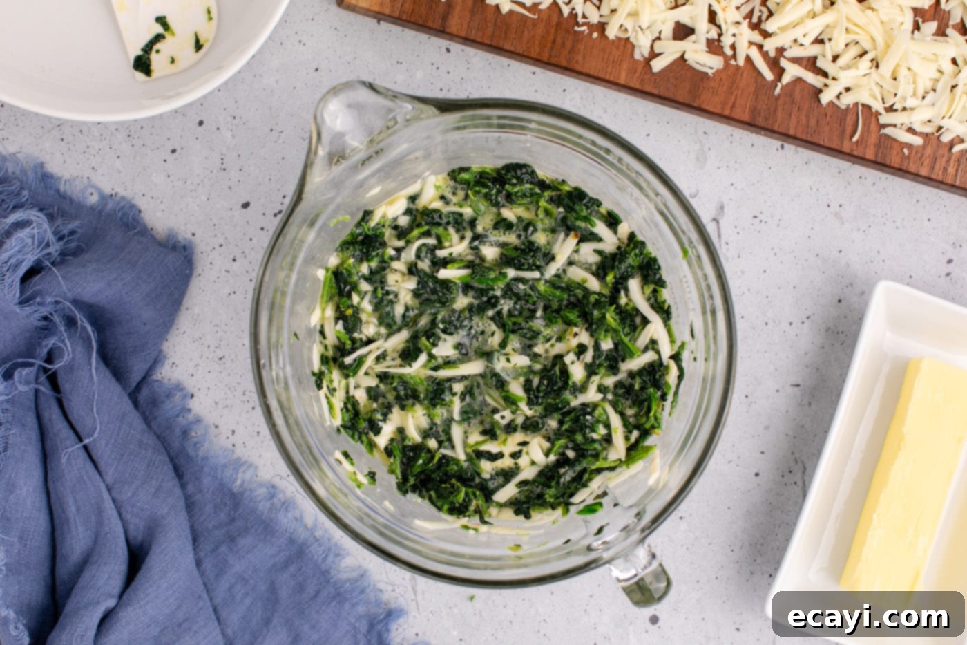 Savory Spinach Cloud 7 All the spinach souffle ingredients, including spinach, cheeses, eggs, garlic, and salt, thoroughly mixed together in a bowl, forming a vibrant green mixture.