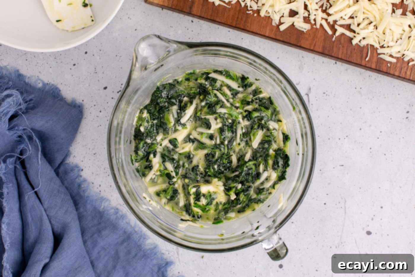 Savory Spinach Cloud 9 The combined spinach souffle mixture, after butter has been added and mixed, sitting in a large mixing bowl before being transferred to a baking dish.