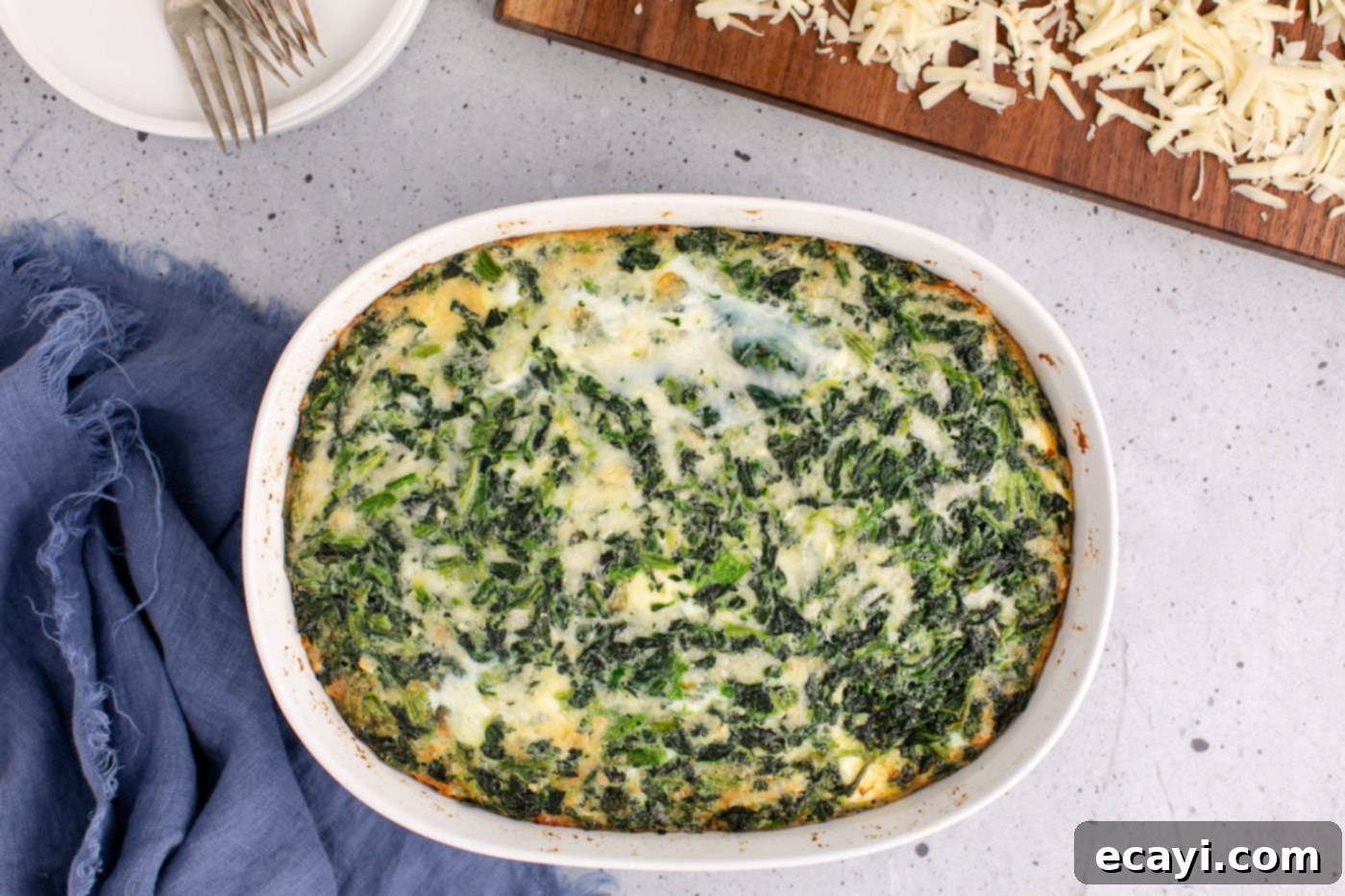 Savory Spinach Cloud 10 A freshly baked spinach souffle in a casserole dish, with a golden-brown edge and a puffed-up center, having just come out of the oven.