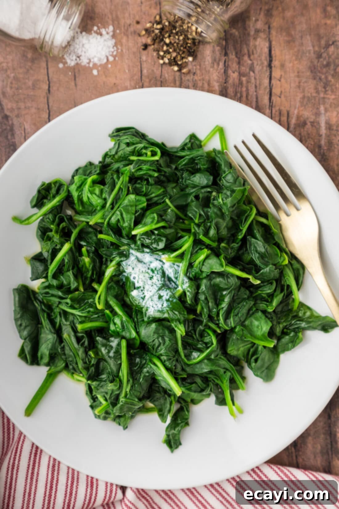 Perfectly Steamed Spinach 2 Freshly Steamed Spinach on a plate with a fork, ready to be enjoyed