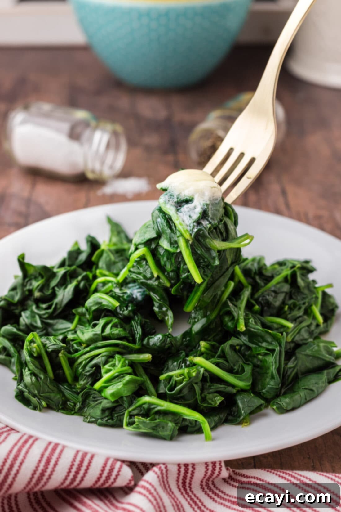Perfectly Steamed Spinach 3 A fork lifting a portion of Steamed Spinach off a plate, showcasing its tender texture