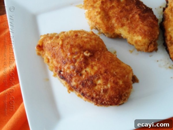 Golden-Crisp Oven Chicken Breasts 12 A close up photo of perfectly cooked oven fried chicken breasts on a white plate, ready to be served as a delightful meal.
