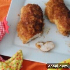 Golden-Crisp Oven Chicken Breasts 13 An overhead photo of two perfectly golden oven fried chicken breasts on a white plate, ready to be enjoyed.