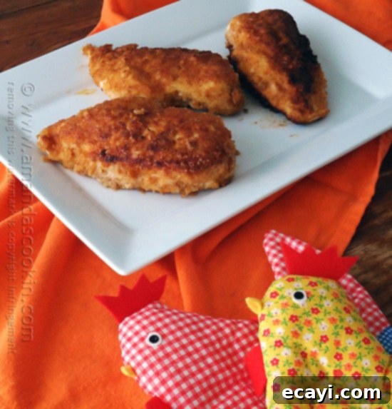 Golden-Crisp Oven Chicken Breasts 3 Three perfectly golden and crispy oven fried chicken breasts served on a white plate, ready to be enjoyed.