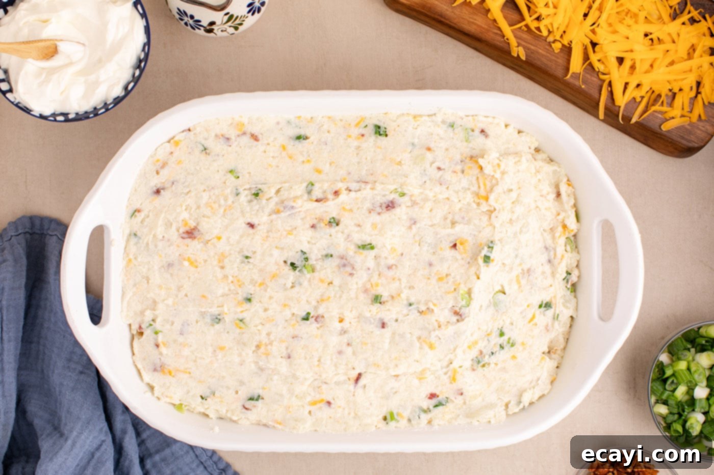 Loaded Cheesy Potato Casserole 11 overhead shot of the creamy potato mixture being spread evenly into a 9x13 casserole dish