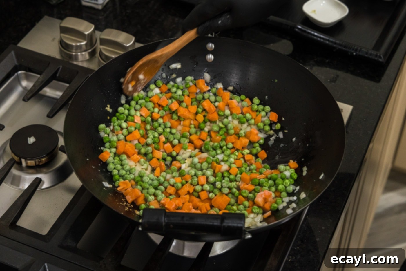 Golden Shrimp Fried Rice 9 stirring peas and carrots into cooked onion and garlic