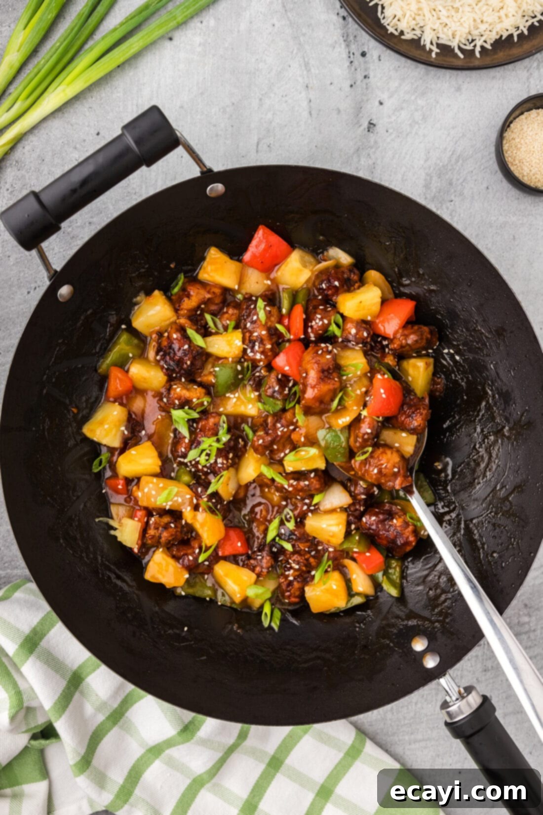 Tangy Glazed Pork Delight 3 Wok of Sweet and Sour Pork with a spoon in it